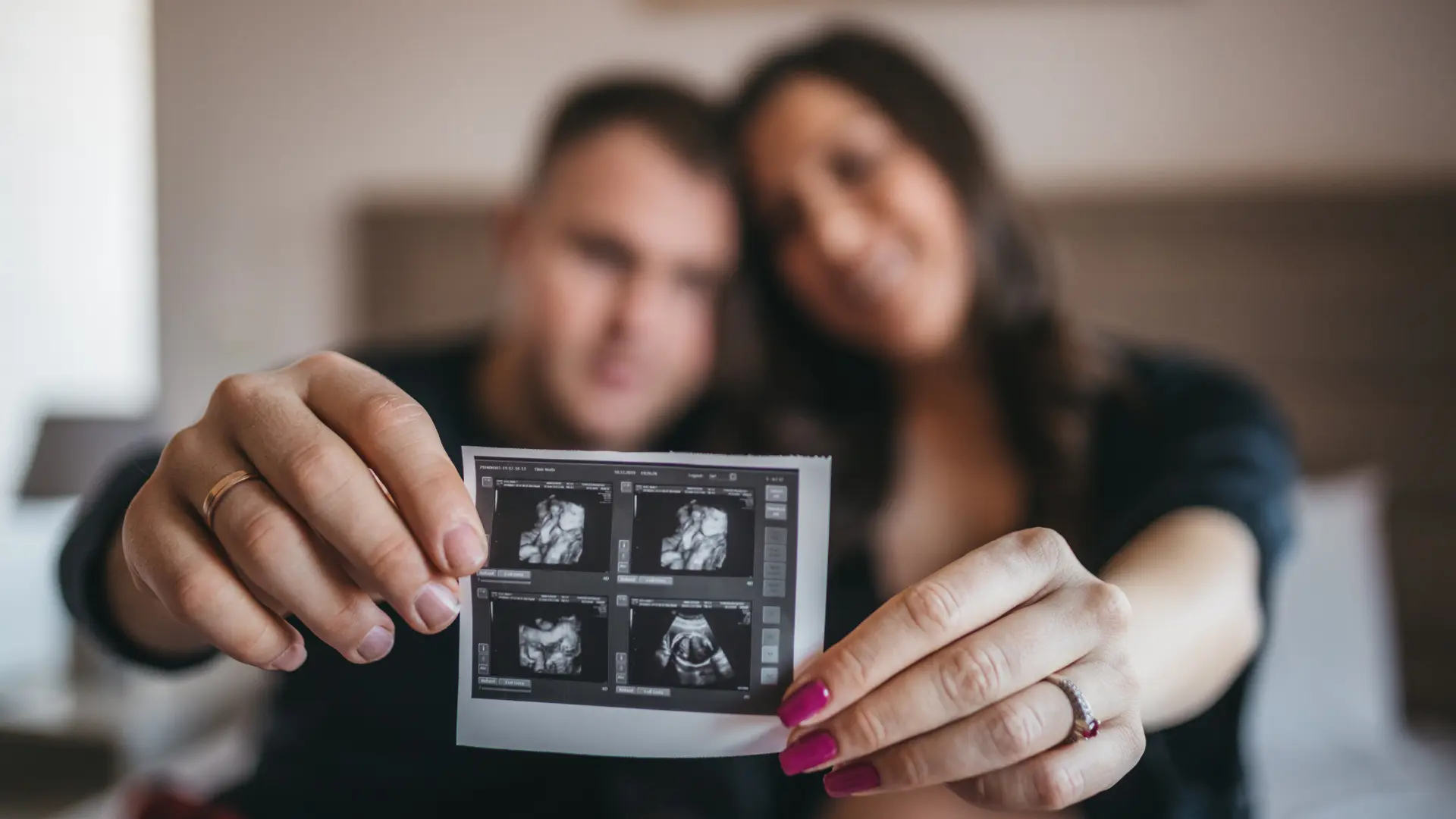 A hopeful couple cherishes their ultrasound photo, a key milestone in their IVF success stories and fertility journey.